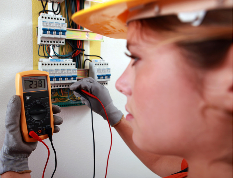 An electrician using a multimeter